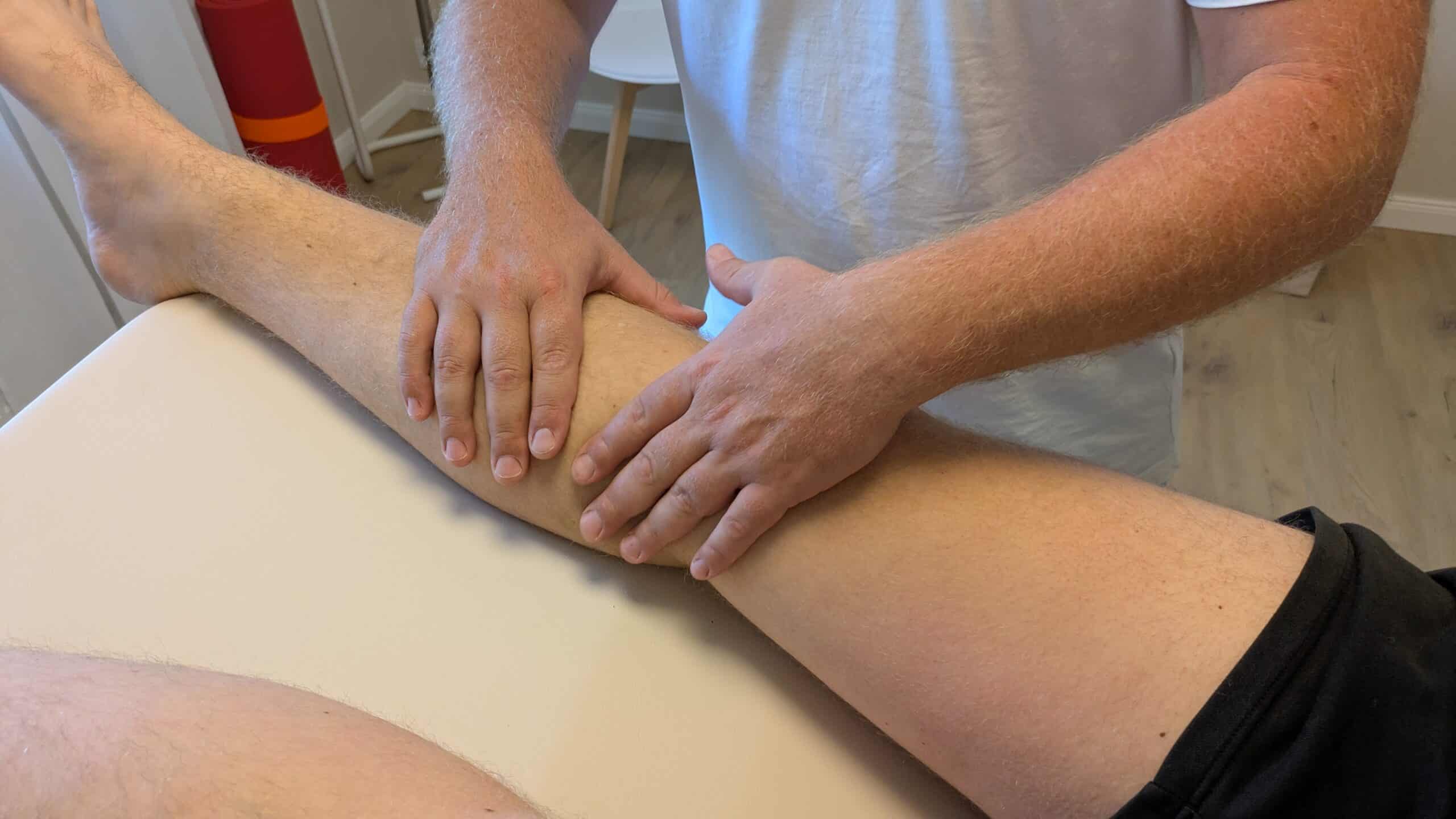 Physiotherapeut behandelt Bein bei Patient in Mainz-Drais.